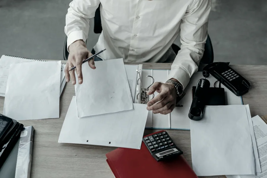 Documentació, una carpeta i una calculadora sobre una taula de treball